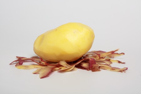 peeled potatoes on the table with a red skinnedの写真素材
