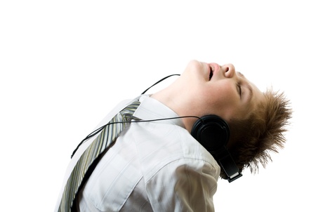Young boy listening to head phones isolated on whiteの写真素材
