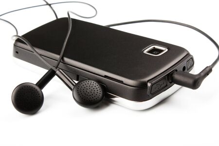 the mobile phone with ear buds isolated on white backgroundの写真素材