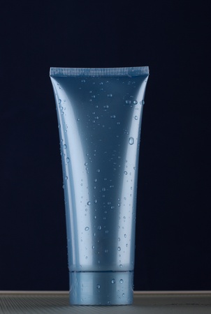 The dark blue tube stands on a cover. Contents of a tube only for men.の写真素材