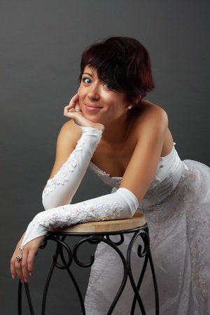 Slim beautiful woman in wedding dress over gray studio backgroundの写真素材