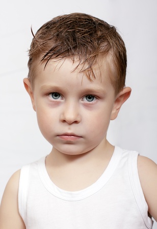 the pensive caucasian boy with wet hairの写真素材