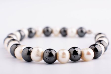 White pearls and black stone beads on a threadの写真素材