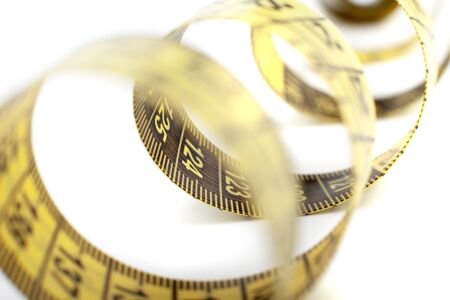 yellow tape measure on the white backgroundの写真素材