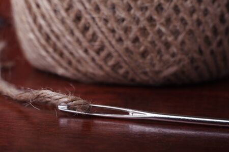 Natural Clew of Twine and Needle on the Wooden Backgroundの写真素材