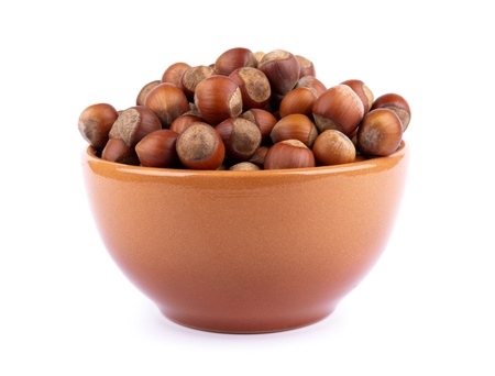 brown earthenware dish with nuts isolated on white backgroundの写真素材