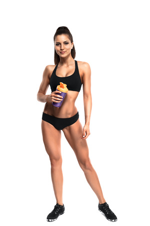 athletic young woman with protein shake bottle. Isolated on white backgroundの写真素材