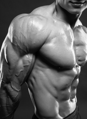 Bodybuilder showing his biceps muscles, personal fitness trainer. Strong man flexing his musclesの写真素材