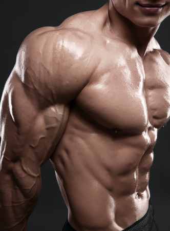 Bodybuilder showing his biceps muscles, personal fitness trainer. Strong man flexing his musclesの写真素材