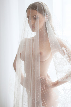Portrait of young beautiful sexy woman in white veil. Sexy bride.の写真素材