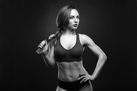 Sexy young woman standing on grey background. Fitness female looking at camera. Concept of sport and healthy lifestyle.の写真素材
