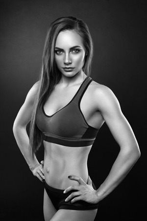 Sexy young woman standing on grey background. Fitness female looking at camera. Concept of sport and healthy lifestyle.の写真素材