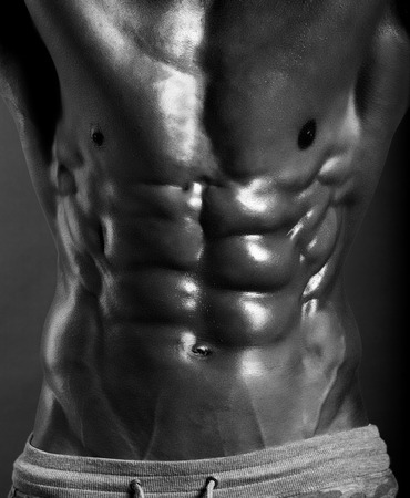 Strong Athletic Man Fitness Model Torso showing six pack abs. isolated on black background with clipping pathの写真素材
