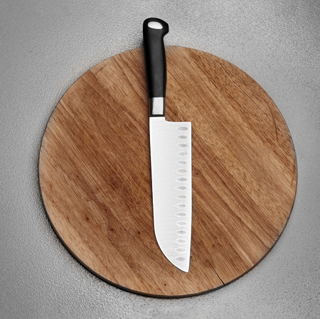 kitchen knife lying on an old cutting boardの写真素材