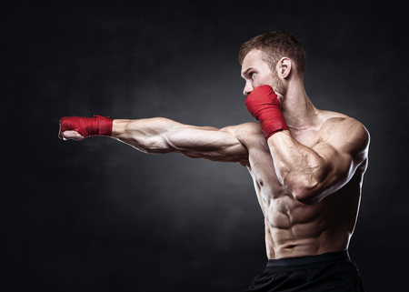 Muscular kickbox or muay thai fighter punching.