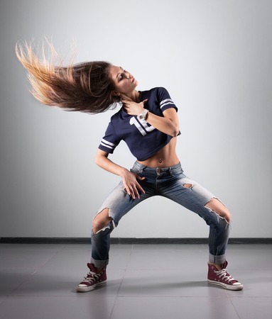 modern young beautiful dancer posing on a studio backgroundの写真素材
