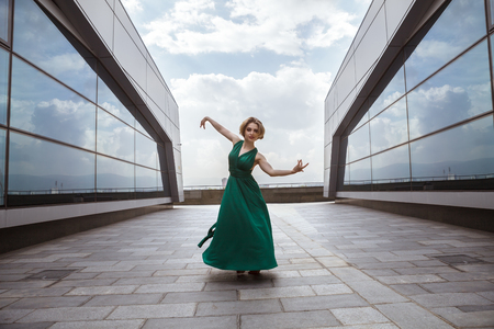 Beautiful girl dancing in the city and jumping against the wall background.の写真素材