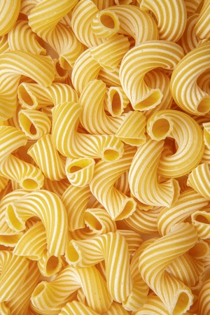 background of pasta in the form of tubes spun in a spiralの写真素材