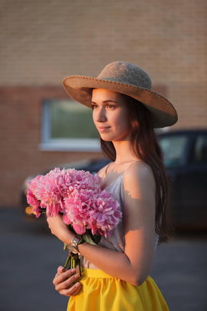 Beautiful girl with a bouquet in the cityの写真素材