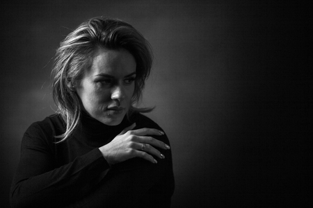 Dramatic black and white portrait of a beautiful woman on a dark backgroundの写真素材
