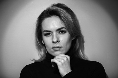 Dramatic black and white portrait of a beautiful woman on a dark background