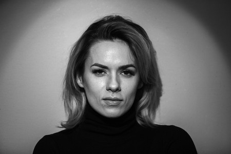 Dramatic black and white portrait of a beautiful woman on a dark backgroundの写真素材