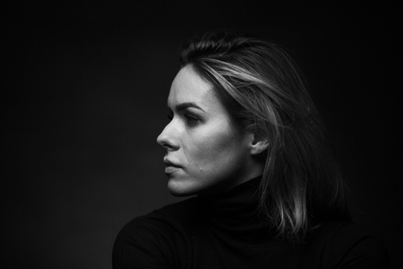 Dramatic black and white portrait of a beautiful woman on a dark background, studio shoot. Concept of natural beauty, no retouch.の写真素材