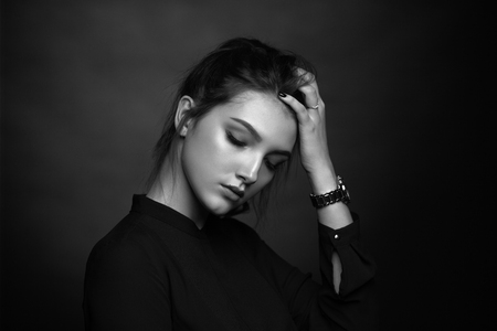 Dramatic black and white portrait of a beautiful girl on a dark backgroundの写真素材