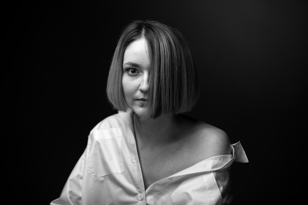 Dramatic black and white portrait of a beautiful woman on a dark backgroundの写真素材