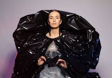 Girl posing in a dress made of plastic film. Fashion portrait.の写真素材