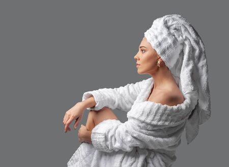Attractive girl wearing white towel on head and white bath robe, smilingの写真素材