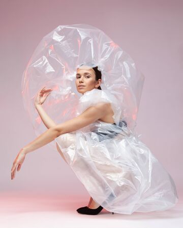 Girl posing in a dress made of plastic film. Fashion portrait.の写真素材