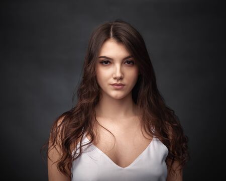 Dramatic portrait of a beautiful girl on a dark backgroundの写真素材