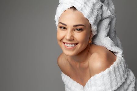 Young woman in a bathrobe and towel on her headの写真素材