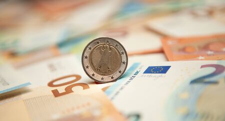 Euro coin rolls against a background of banknotes.の写真素材