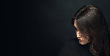 Portrait of a beautiful girl on a darkの写真素材