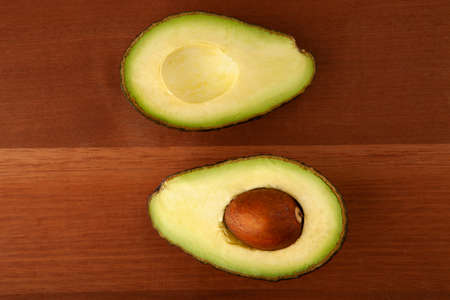 Closeup Avocado cut in half on wooden board background