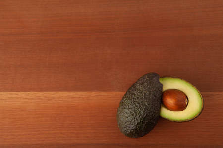 Closeup Avocado cut in half on wooden board backgroundの写真素材
