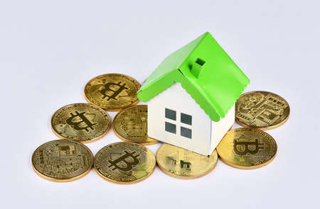 Photo pour Conceptual image for investors in cryptocurrency (new virtual money). Mini model house on stacks of Bitcoins. Property investment and house mortgage financial concept. - image libre de droit - Pay Rent with Bitcoin, Is it Worth?