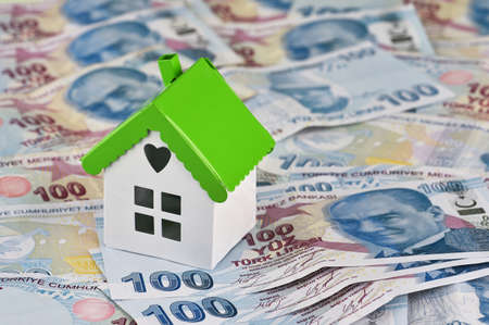 Mini model house on stacks of Turkish Lira Banknotes. Property investment and house mortgage...
