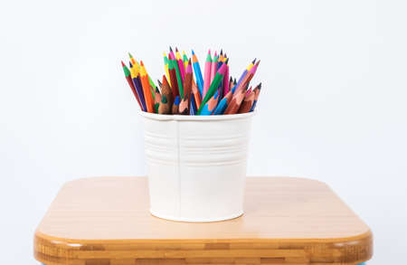 Colored pencils in a white metallic pencil case on white background.の写真素材