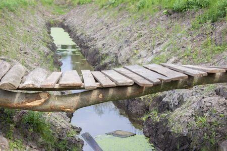 old wooden bridge across the water channelの写真素材