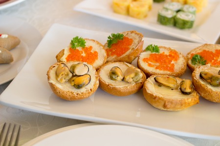 sandwiches with mussels and caviar on the tableの写真素材