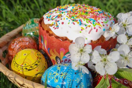 Easter background,Beautiful easter easter eggs with flowers and squash in basket on grass background