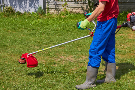 gardener with professional tool for cutting grass, cutting grassの写真素材