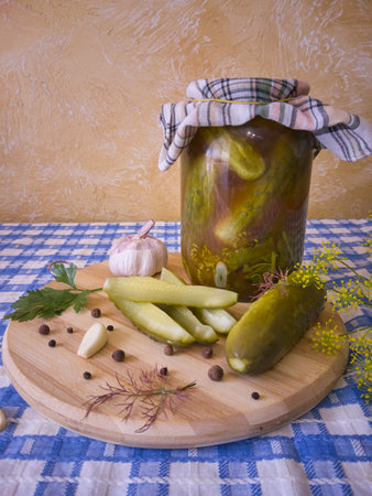 Glass jars with pickled cucumbers. Jars with pickled vegetables. Preserved food concept in a rustic composition.の写真素材