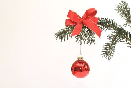 Christmas decoration hanging on a christmas tree branch with a red ribbonの写真素材