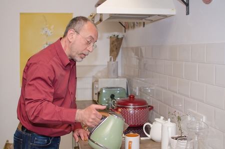 Aged man cooking on the kitchenの写真素材