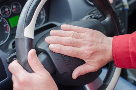 Aged man in the car on the streetの写真素材