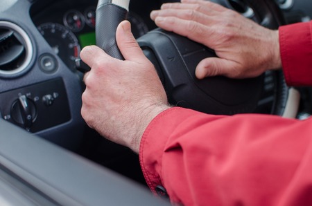 Aged man in the car on the streetの写真素材